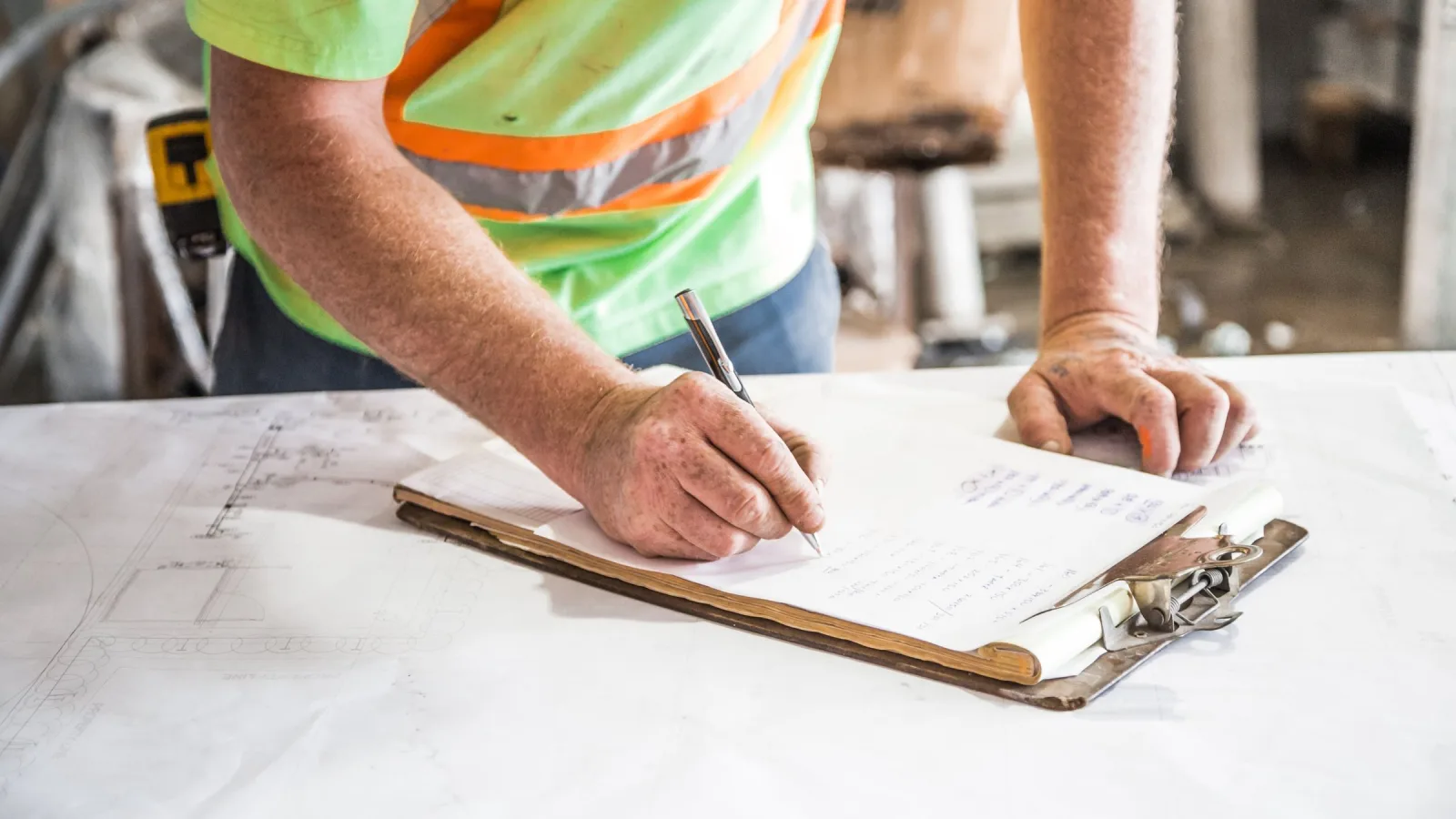 Worker documenting revised project plans on a clipboard