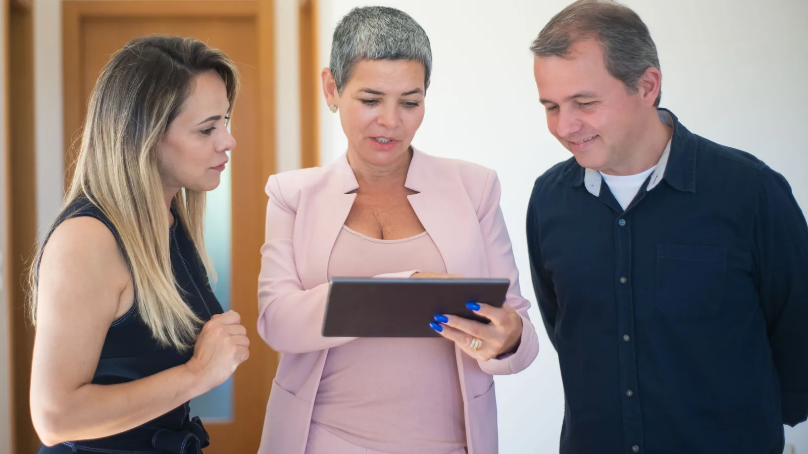 Professional reviewing project options on a tablet with two people
